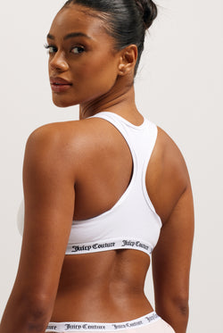 Displays a model wearing the White 'juicy' branded cotton bralette 