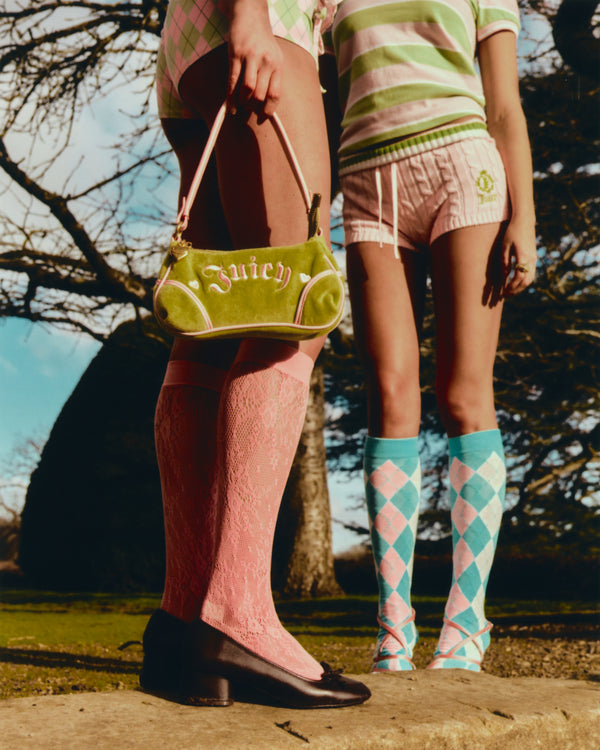 Displays a model holding the Pistachio Green and Pink 'Juicy' branded velour mini handbag 