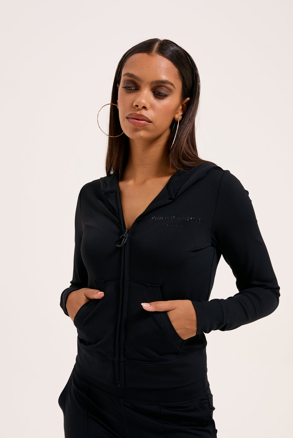 Displays a model wearing the black peached 'juicy' branded active fitted hoodie 
