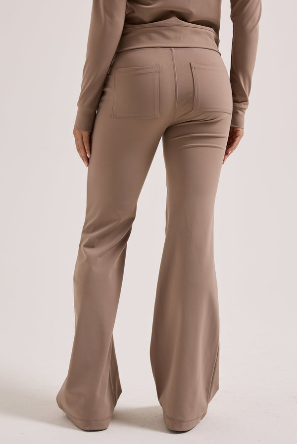 Displays a model wearing the Fungi peached 'Juicy' branded active low rise pants 