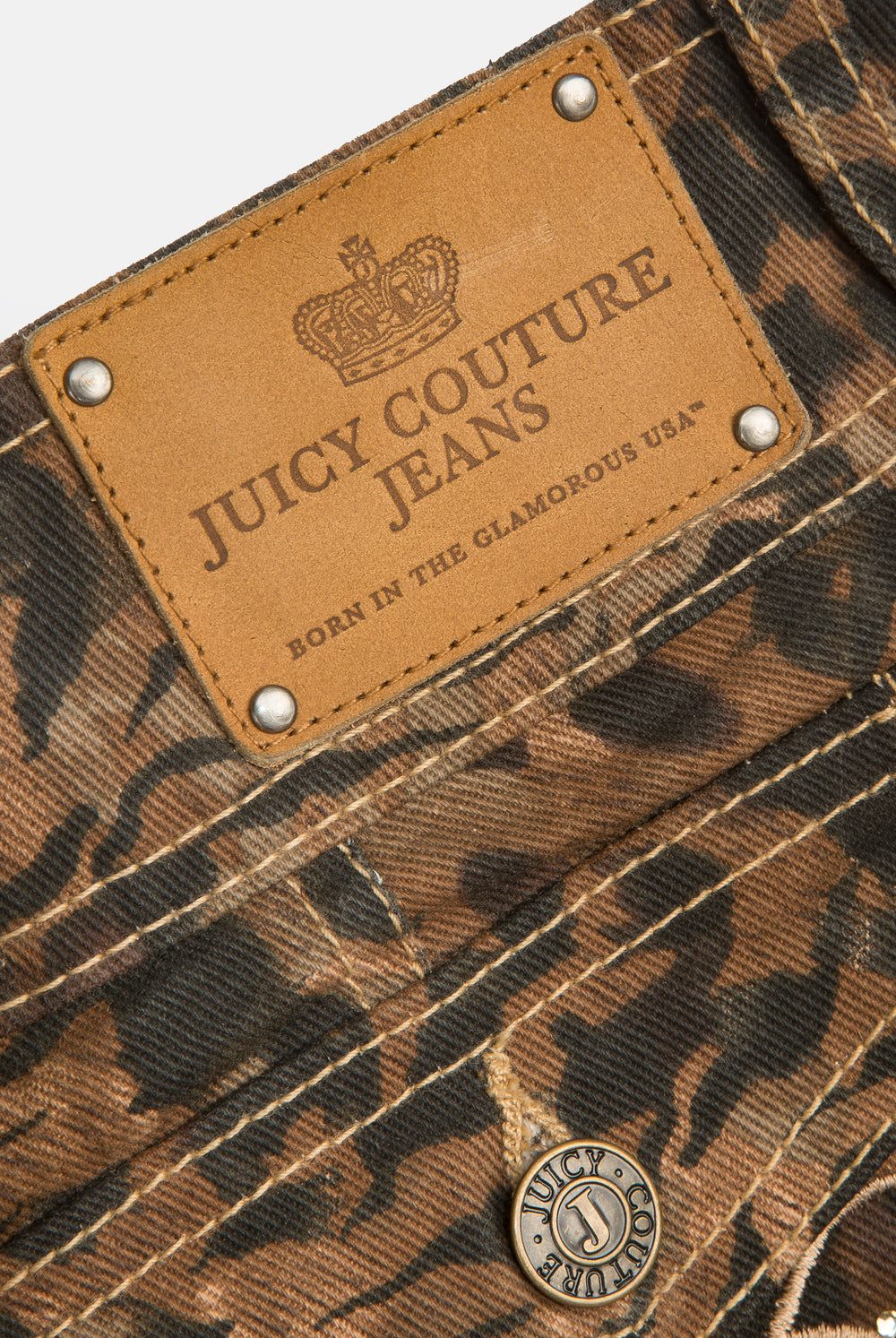 Displays the animal 'Juicy' branded denim lace up shorts featuring the close up on the juicy couture branding 