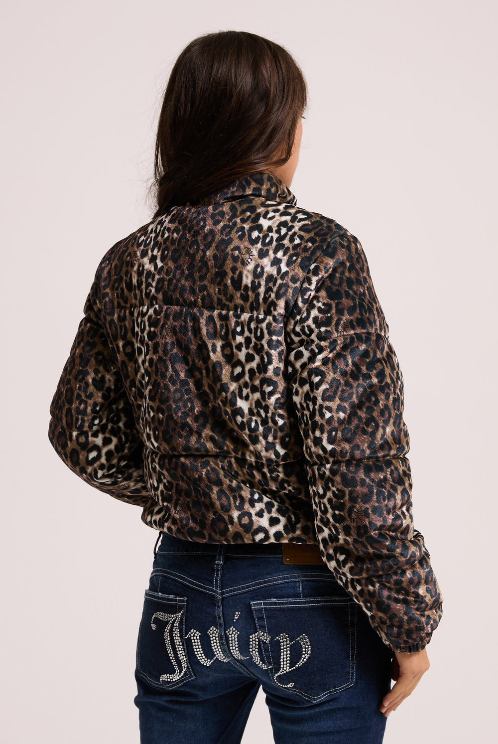 Displays a model wearing the leopard print velour 'Juicy' branded puffa jacket