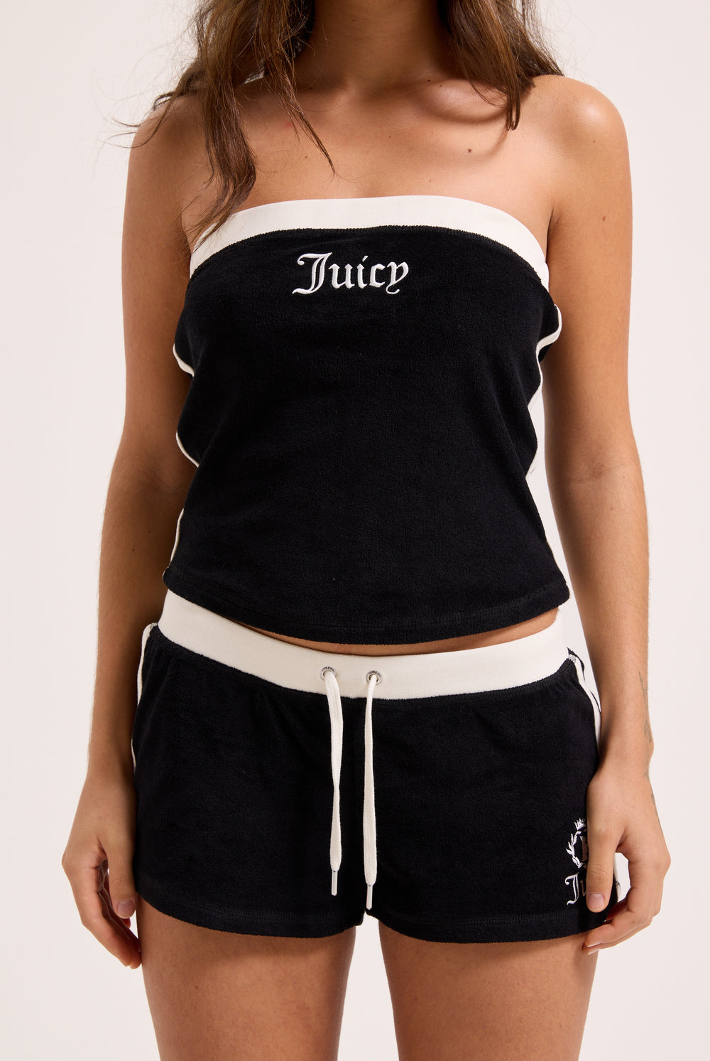 Displays a model wearing the Black Appliqué 'Juicy' branded  Terry booty shorts 