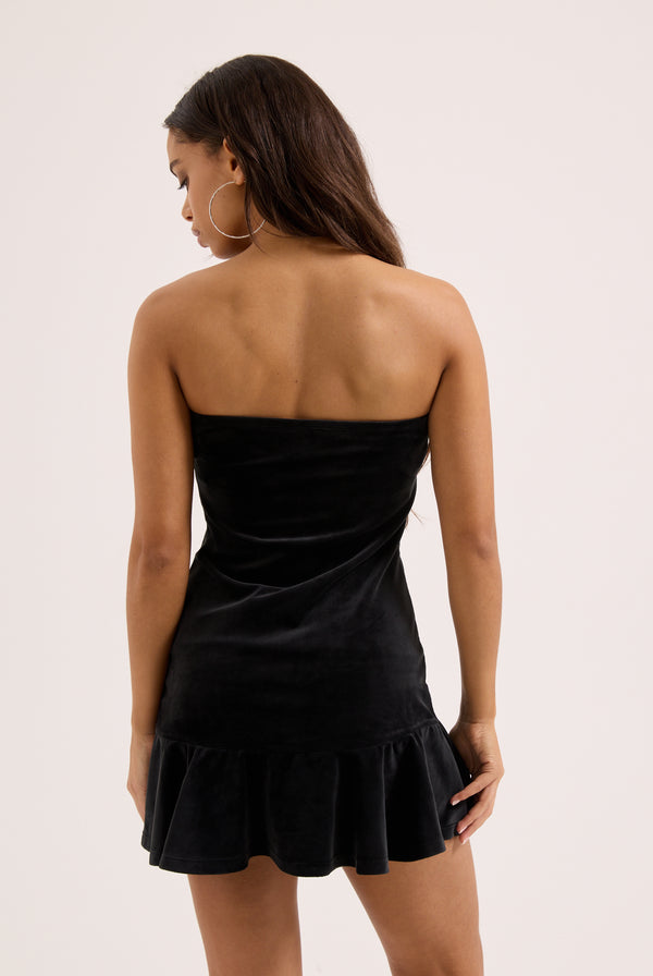 Displays a model wearing the Black Bandeau Ruffle 'Juicy' branded velour dress 