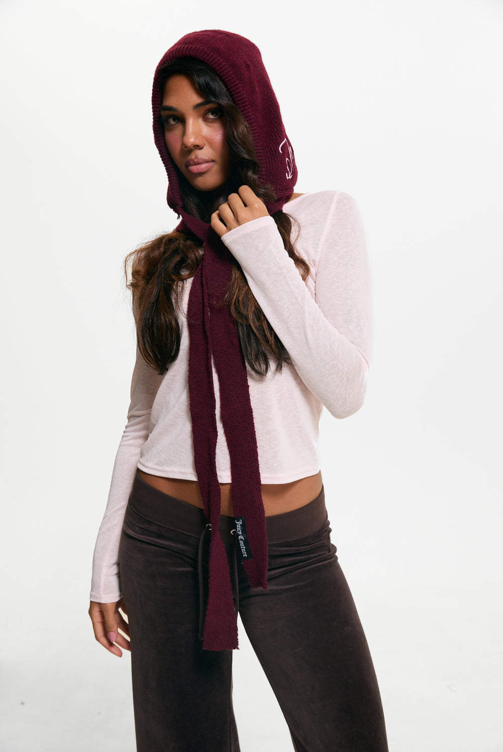 Displays a model wearing the Burgundy 'Juicy' branded Bonnet With Bow