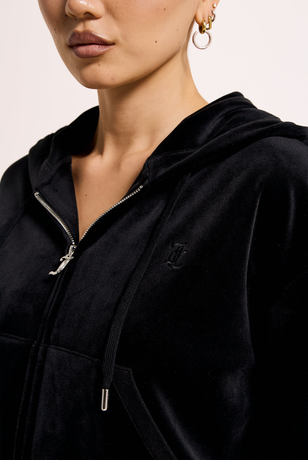 Displays a model wearing the Black 'Juicy' branded crop oversized classic velour hoodie 