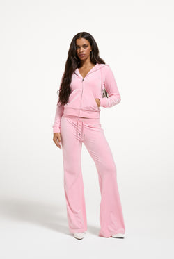 Displays a model wearing the Juicy Pink 'Juicy' branded bridesmaid classic velour low rise track pants 