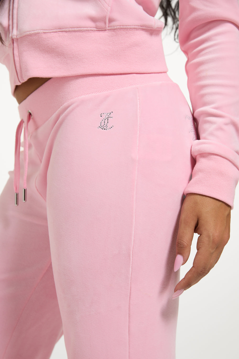 Displays a model wearing the Juicy Pink 'Juicy' branded bridesmaid classic velour low rise track pants 