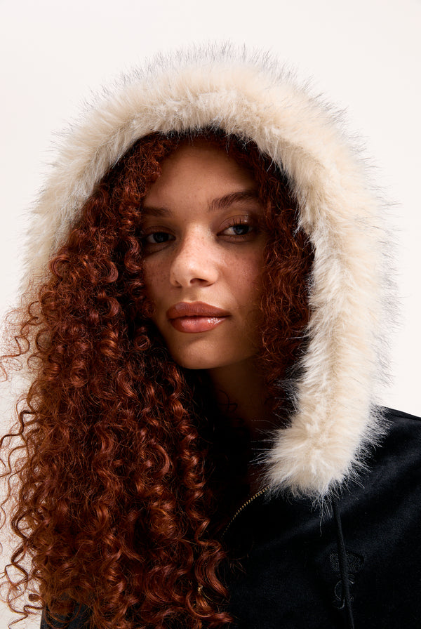 Displays a model wearing the Black 'Juicy' branded Pom Pom faux fur bamboo velour hoodie 