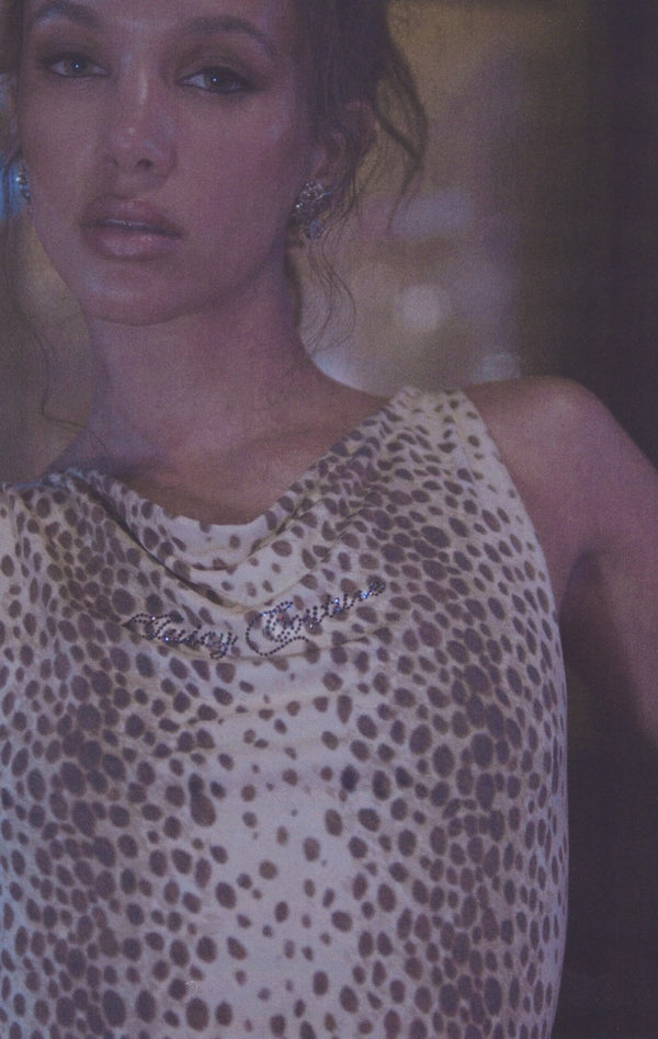 Displays a model wearing the natural cheetah print 'Juicy' off the shoulder top 