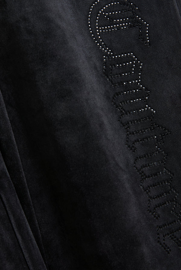 Displays the Black outline 'Juicy' branded diamanté classic velour low rise pant featuring the juicy branding 