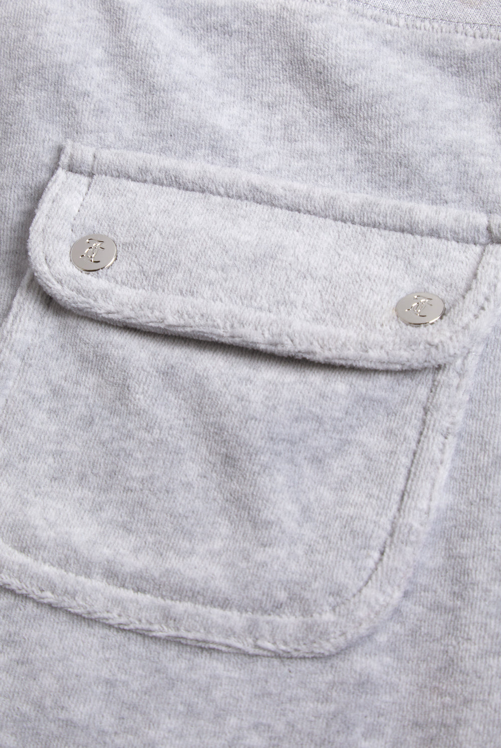 Close-up of the back pocket, showing a more detailed view of the Juicy Couture logo on the silver buttons
