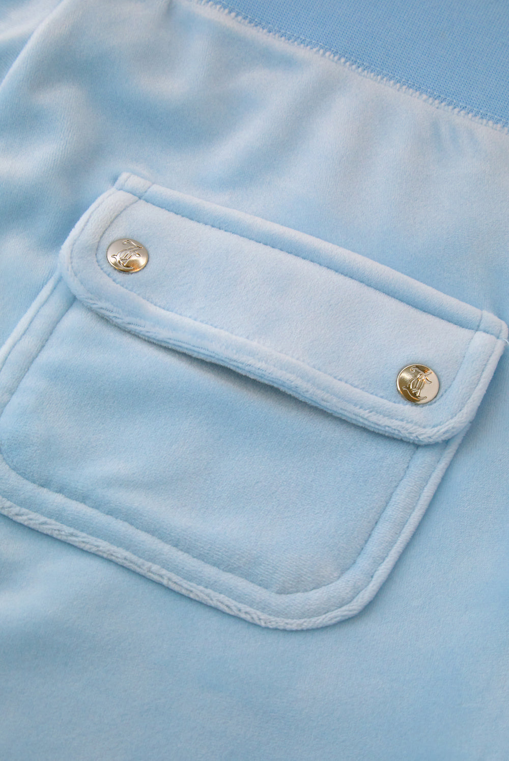 Displays a model wearing the Powder blue classic 'Juicy' branded velour del ray pocketed bottoms featuring the pocket
