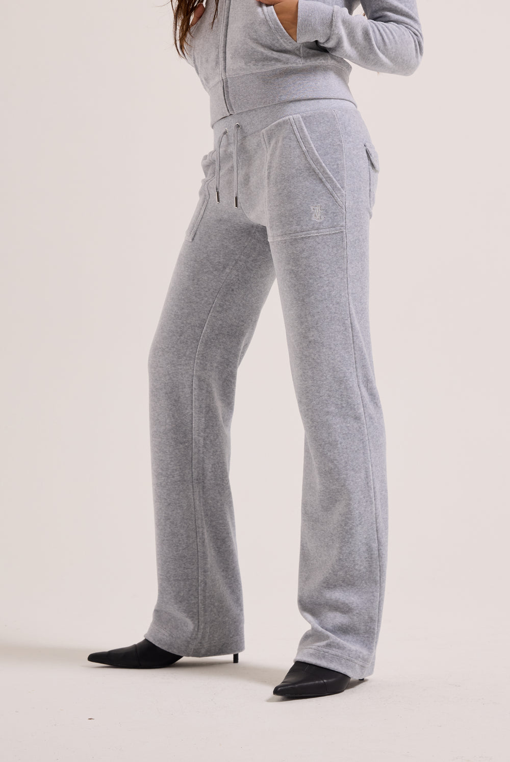 Person wearing a gray tracksuit on a plain background