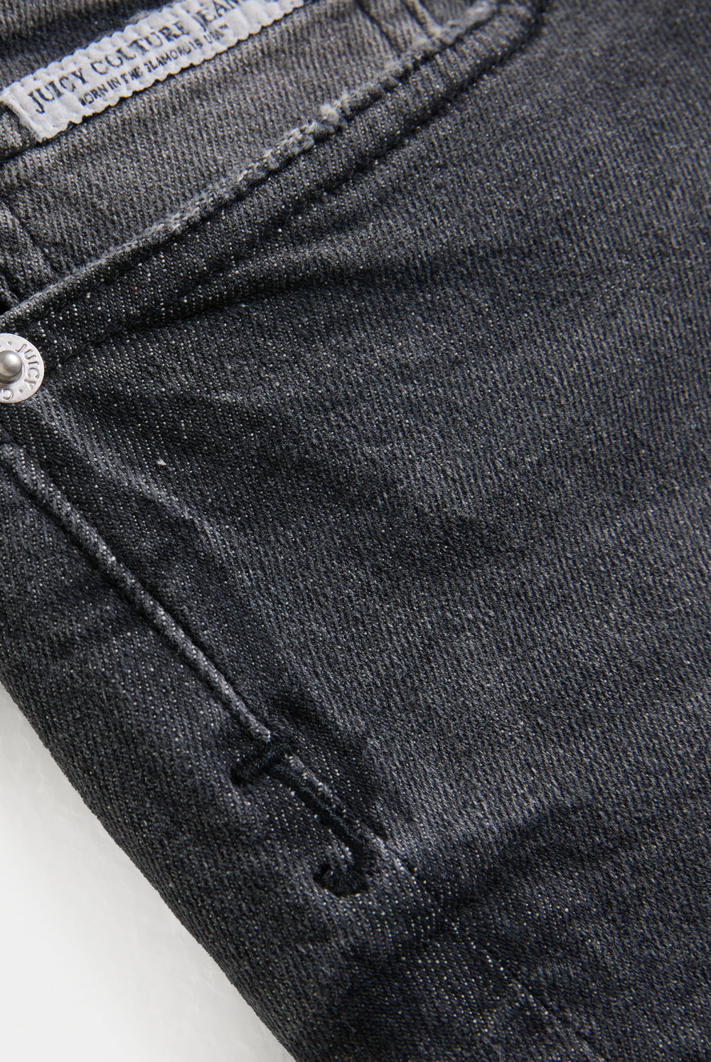 Displays a models wearing the Washed Black 'Juicy' branded low rise denim booty shorts featuring the juicy logo