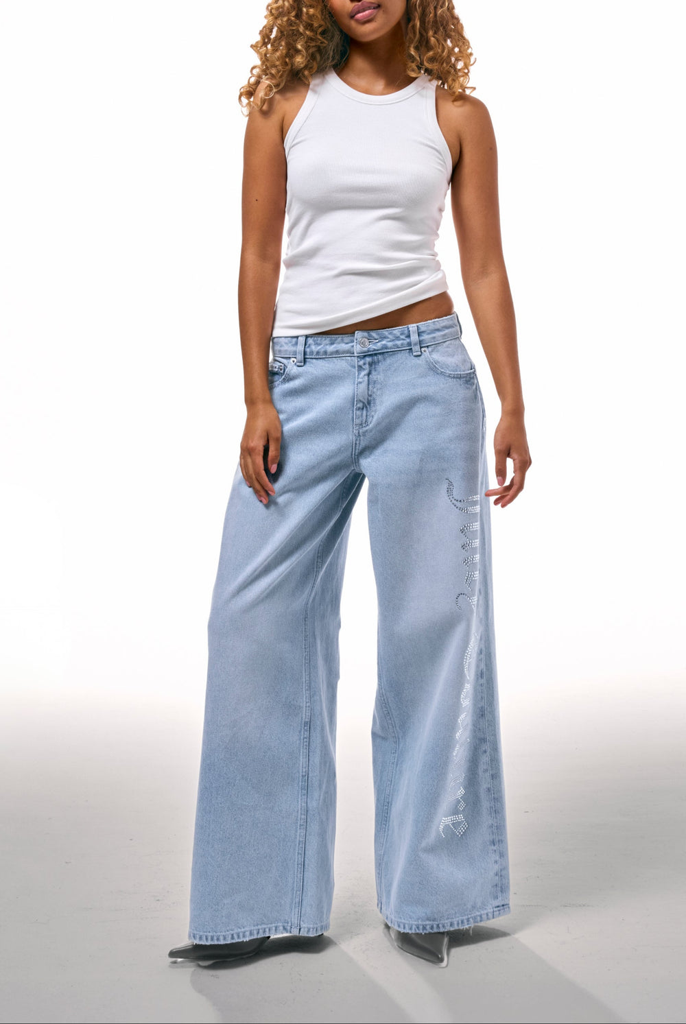 Displays a model wearing the Light Wash Diamanté 'Juicy' branded wide leg jeans 