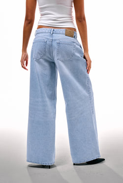Displays a model wearing the Light Wash Diamanté 'Juicy' branded wide leg jeans 