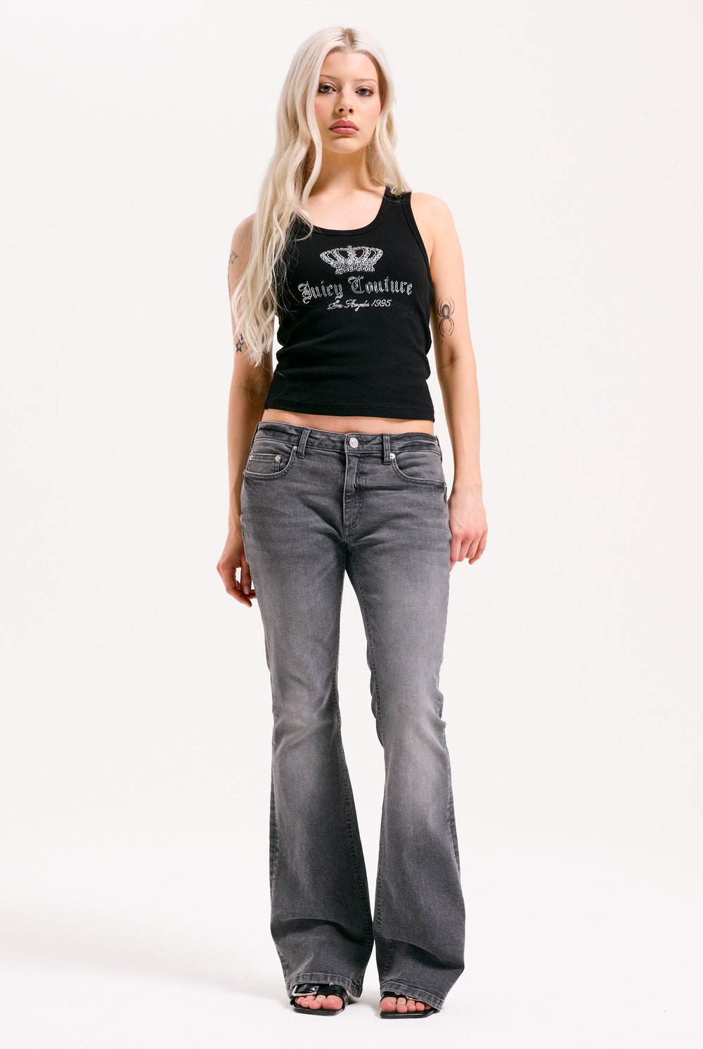 Displays a model wearing the grey wash 'Juicy' branded Digi diamanté mid rise flared jeans 