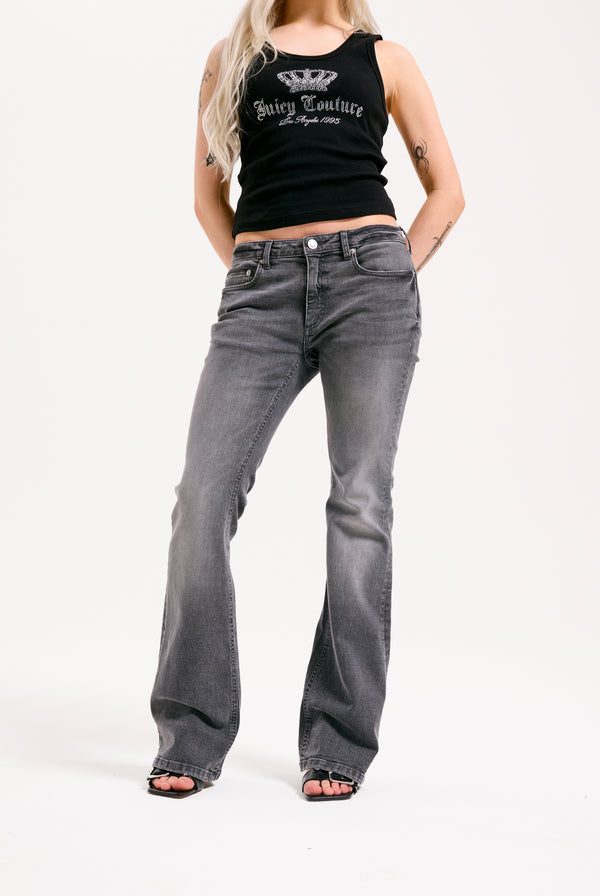 Displays a model wearing the grey wash 'Juicy' branded Digi diamanté mid rise flared jeans 
