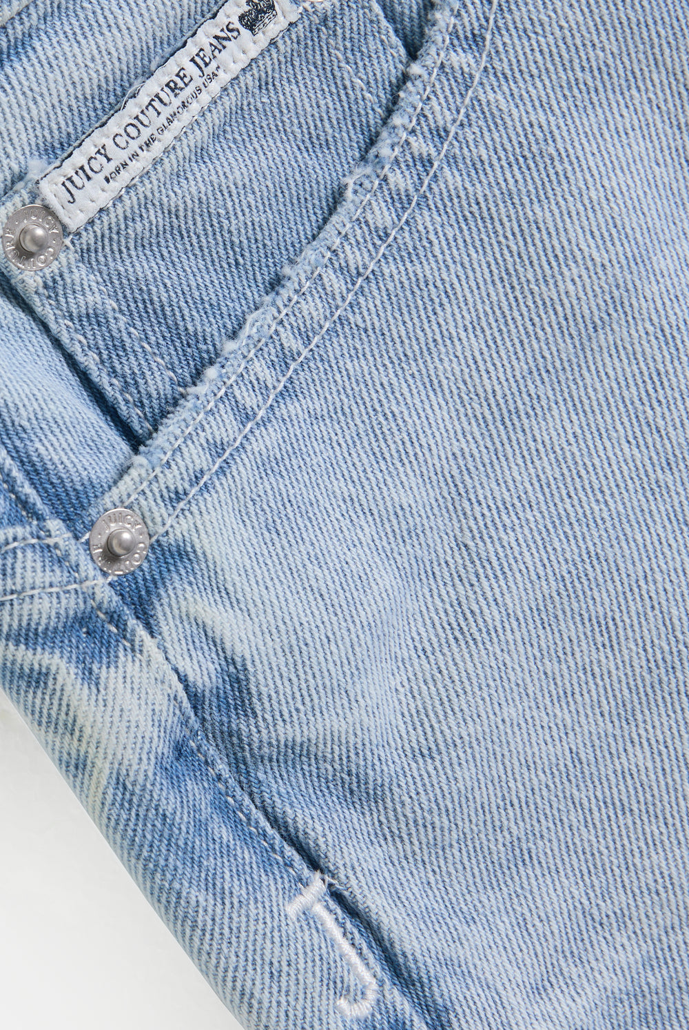 Displays the Light Wash 'Juicy' branded denim dog crest mini skirt 