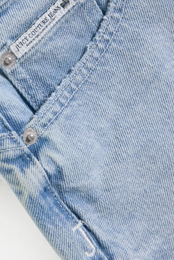 Displays the Light Wash 'Juicy' branded denim dog crest mini skirt 