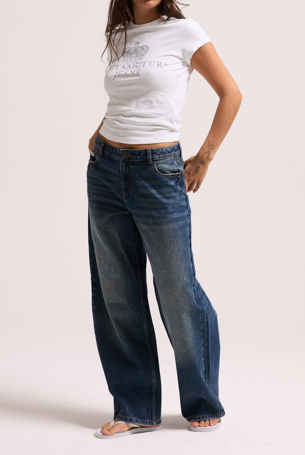 Displays a model wearing the vintage wash mid rise wide leg 'Juicy' branded jeans 