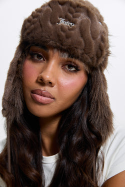 Displays a model wearing the Java 'Juicy' branded Cable Knit Trapper With Fur Lining
