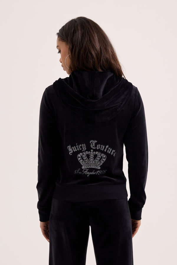 Displays a model wearing the black 'juicy' branded diamanté crown OG Straight low rise velour bottoms 