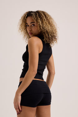Displays a model wearing the Black 'Juicy' Branded Luxury Jersey Roll down Diamanté shorts with the matching Juicy top