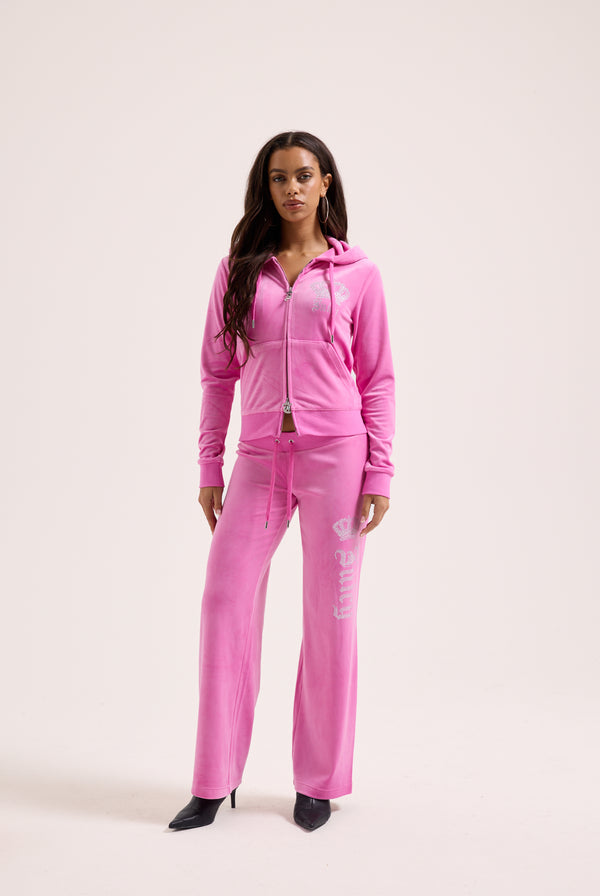 Displays a model wearing the super pink 'Juicy' branded diamanté crown OG straight low rise velour bottoms 