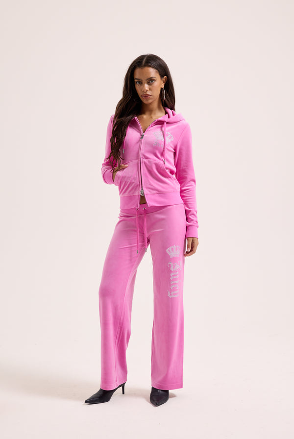 Displays a model wearing the super pink 'Juicy' branded diamanté crown OG straight low rise velour bottoms 