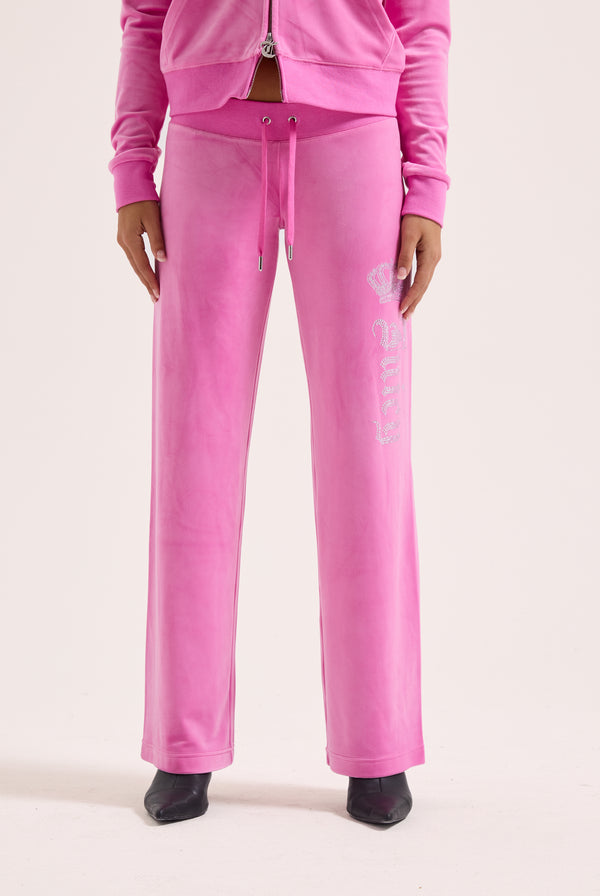 Displays a model wearing the super pink 'Juicy' branded diamanté crown OG straight low rise velour bottoms 