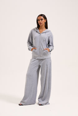 Displays a model wearing the silver marl wide leg 'Juicy' branded cotton velour track pant