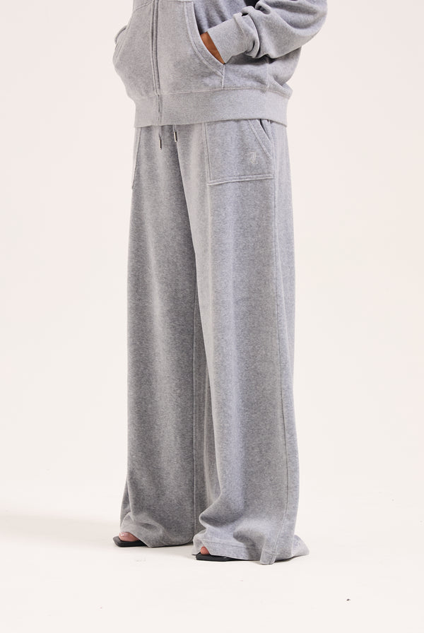 Displays a model wearing the silver marl wide leg 'Juicy' branded cotton velour track pant