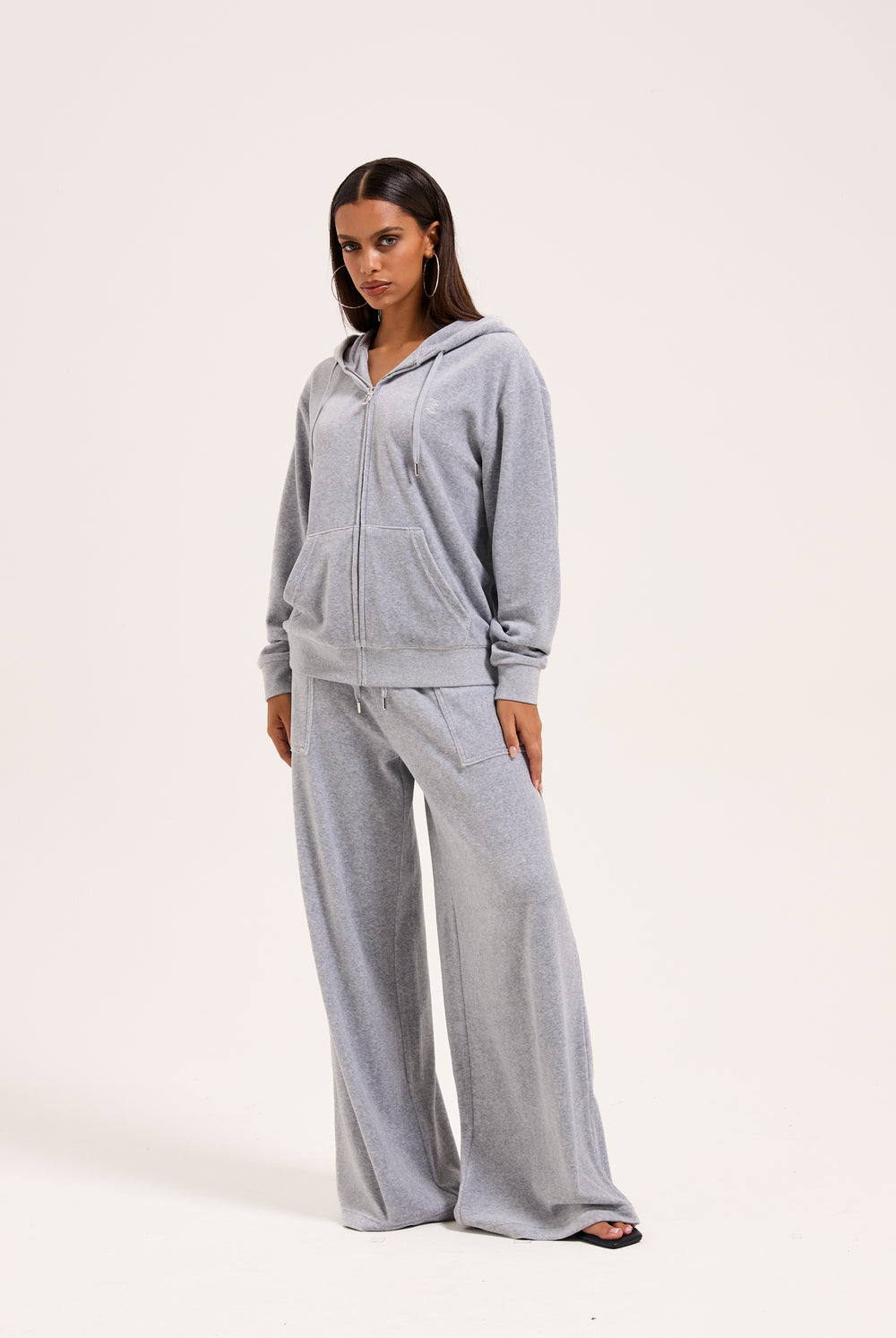 Displays a model wearing the silver marl wide leg 'Juicy' branded cotton velour track pant