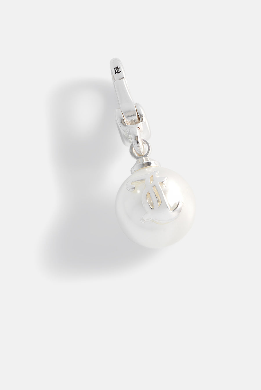 Displays the silver 'Juicy' branded JC pearl charm 