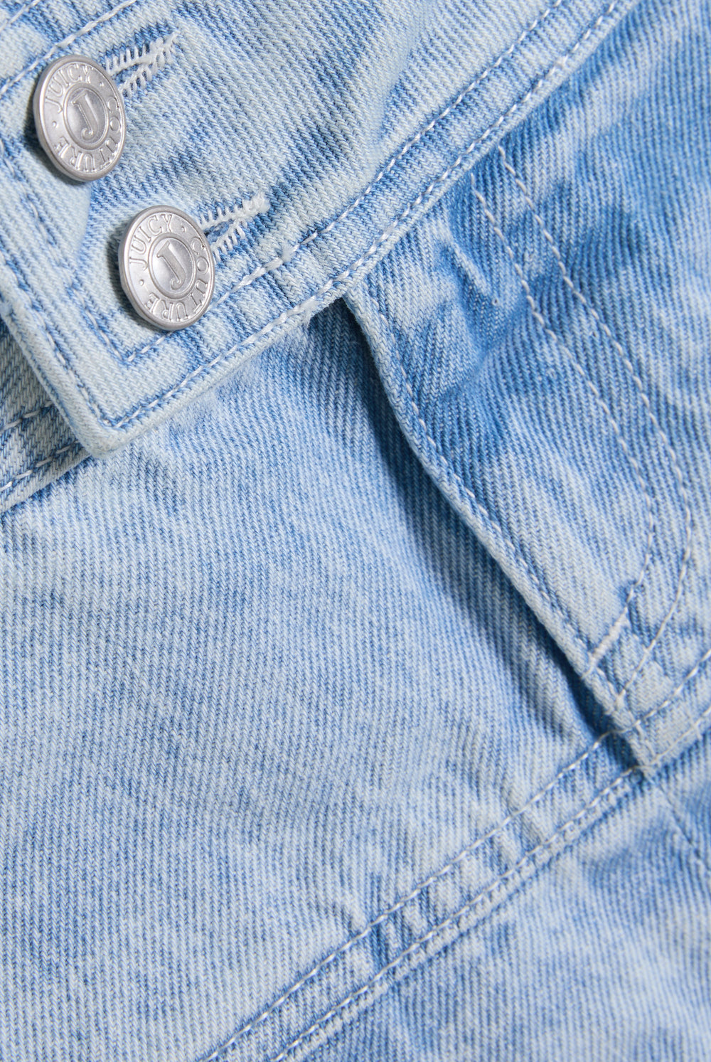 Displays a model wearing the light wash  'juicy' branded denim pleated mini skirt 