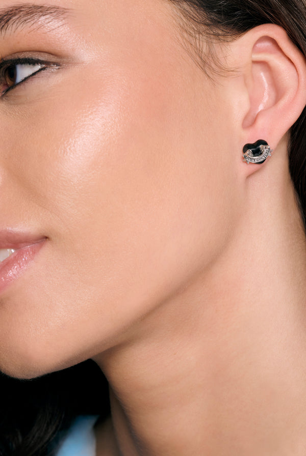 Displays a model wearing the Silver Tone 'Juicy' branding enamel icon heart stud earrings 