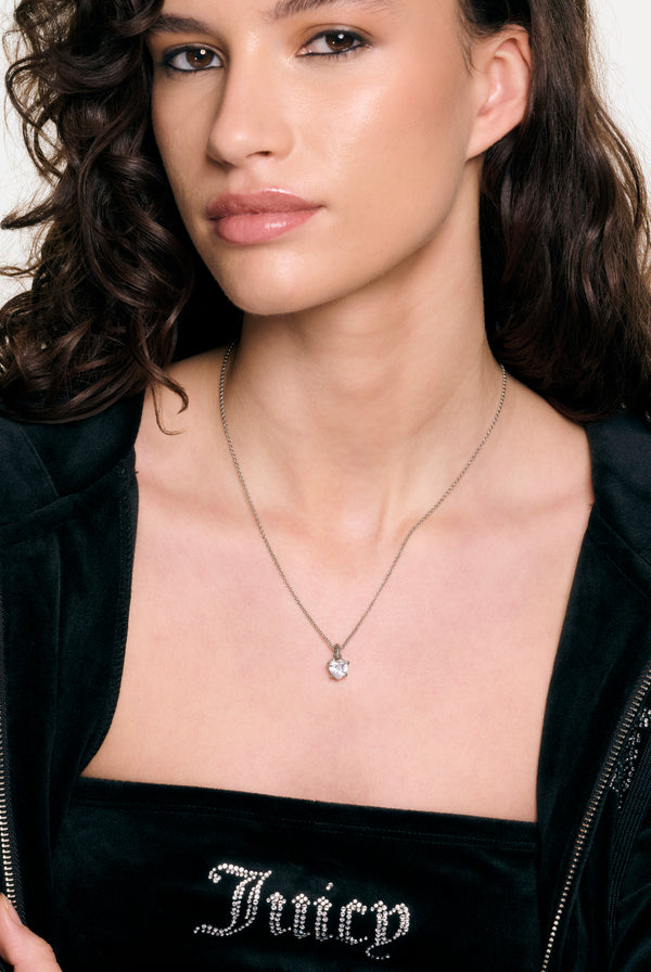 Displays a model wearing the silver tone 'juicy' branded solitaire crystal heart pendant 