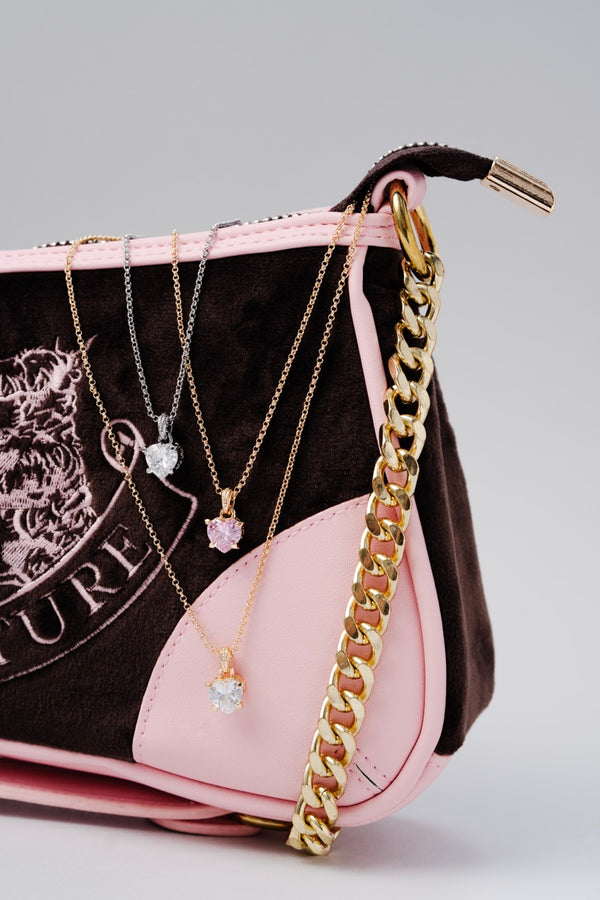 Displays the 'Juicy' handbag featuring the Juicy Silver Tone Solitaire Crystal Heart Pendant