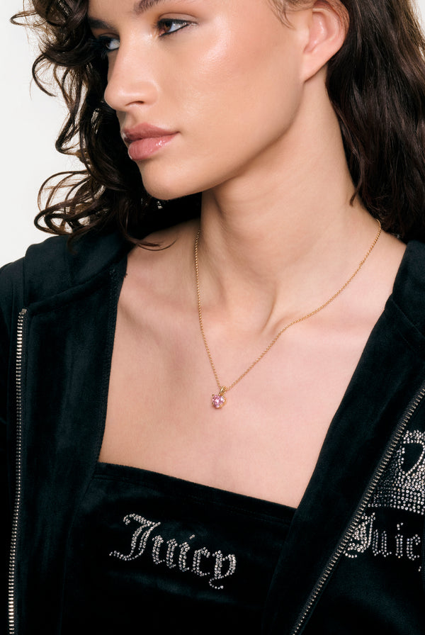 Displays a model wearing the Gold Tone 'Juicy' branded solitaire crystal heart pendant