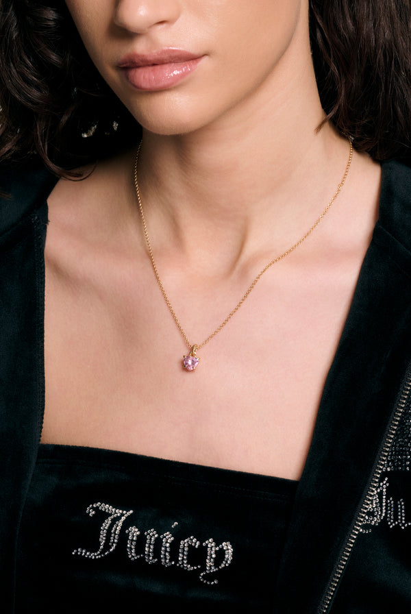 Displays a model wearing the Gold Tone 'Juicy' branded solitaire crystal heart pendant