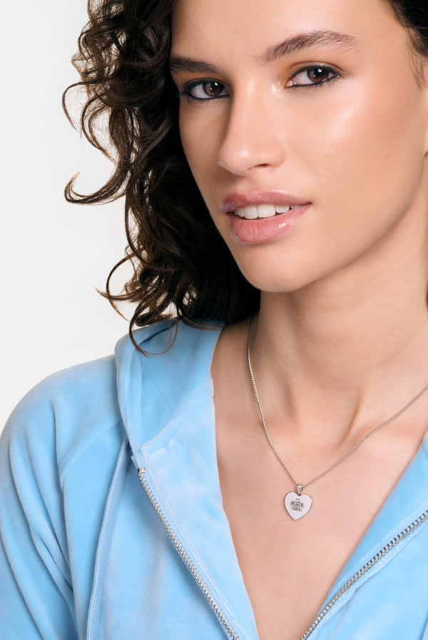 Displays a model wearing the Silver Tone 'Juicy' branded reversible heart pendant 