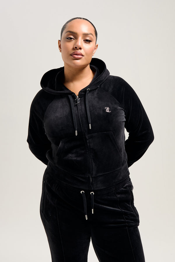 Displays a model wearing the Black 'Juicy' branded 'LEO' Diamanté velour zip through hoodie 