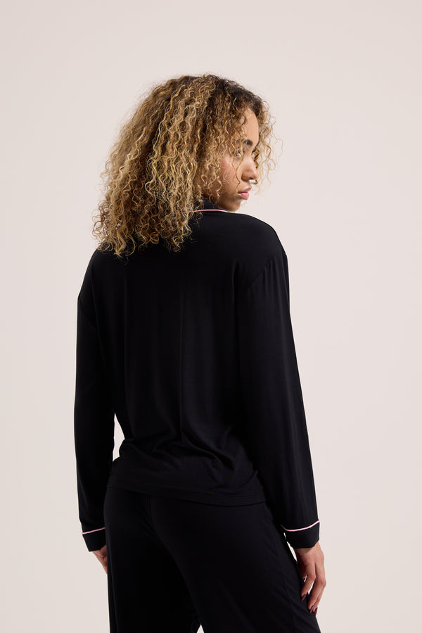 Displays a model wearing the Black 'Juicy' branded Juicy Dog crest pyjama set 