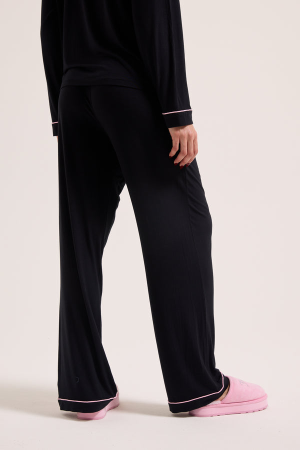 Displays a model wearing the Black 'Juicy' branded Juicy Dog crest pyjama set 