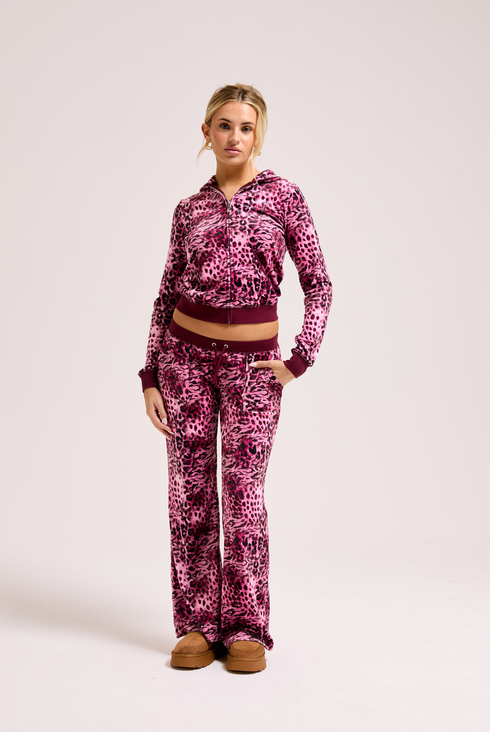 Displays a model wearing the Pink Leopard print 'Juicy' branded pocketed tracksuit bottom featuring the matching top 