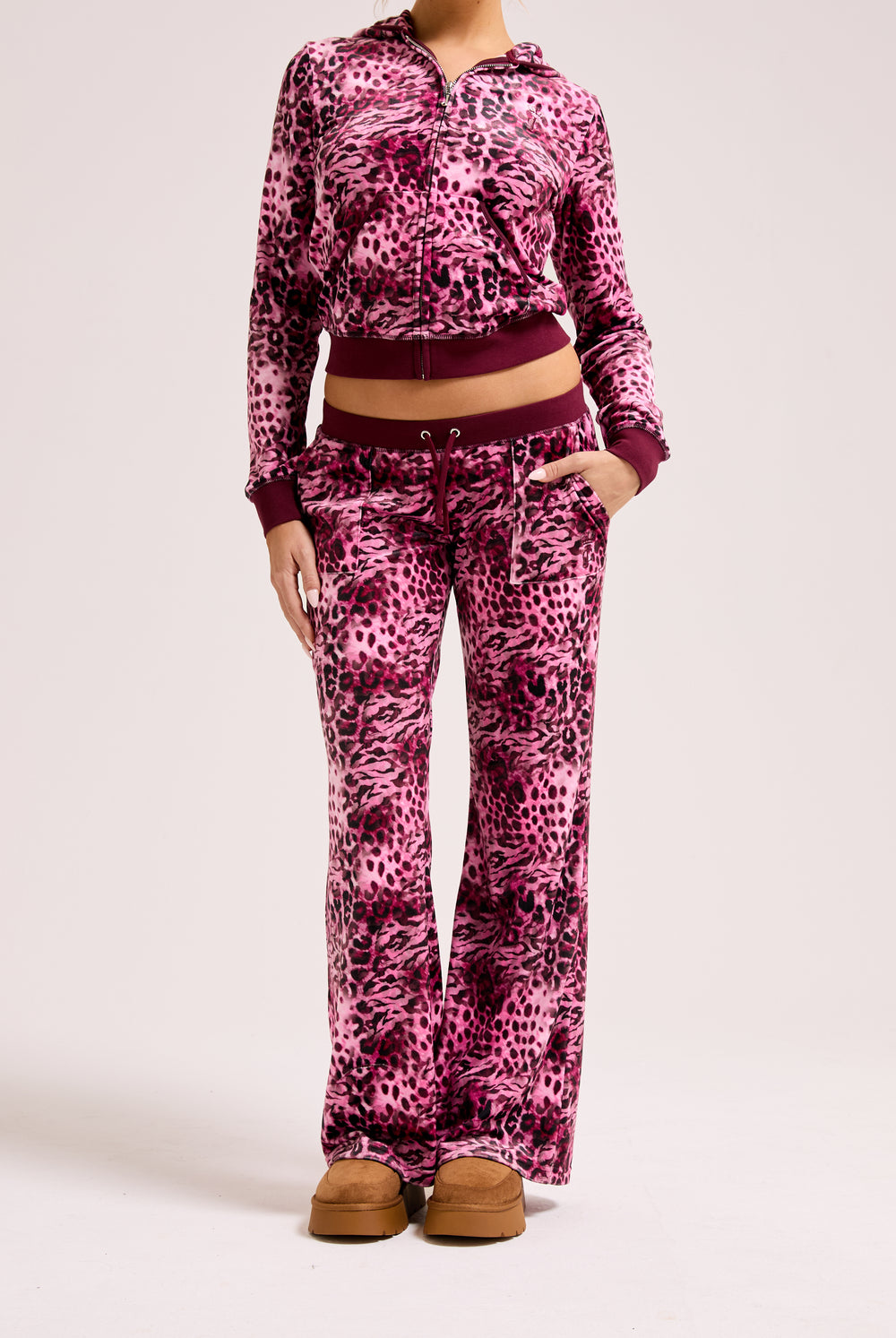 Displays a model wearing the Pink Leopard print 'Juicy' branded pocketed tracksuit bottom featuring the matching top 