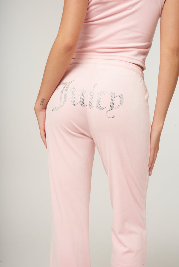 Displays a model wearing the Almond Blossom 'Juicy' branded velour diamanté tracksuit bottom 
