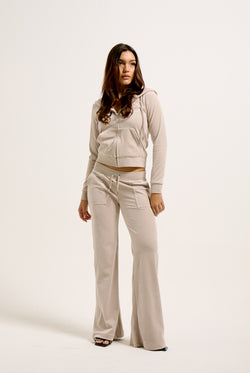 Displays a model wearing the String 'Juicy' branded classic velour del ray pocketed bottoms 